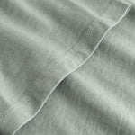 Closeup view of arm stitchings on grey T-shirt