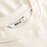 Closeup view of Nikben necklabel on cream colored T-shirt