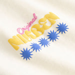 Closeup view of yellow, blue and pink Nikben logo on cream colored T-shirt