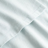 Closeup view of arm stitchings on pale blue T-shirt