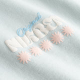 Closeup view of multicolored Nikben logo on pale blue T-shirt