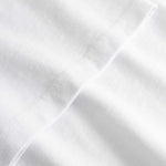 Closeup view of arm stitchings on white T-shirt
