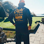 model wearing a full sweatsuit with 'Capri Motel' text on the back