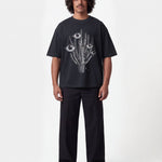 Male model wearing black T-shirt with black and white cactus print in the middle
