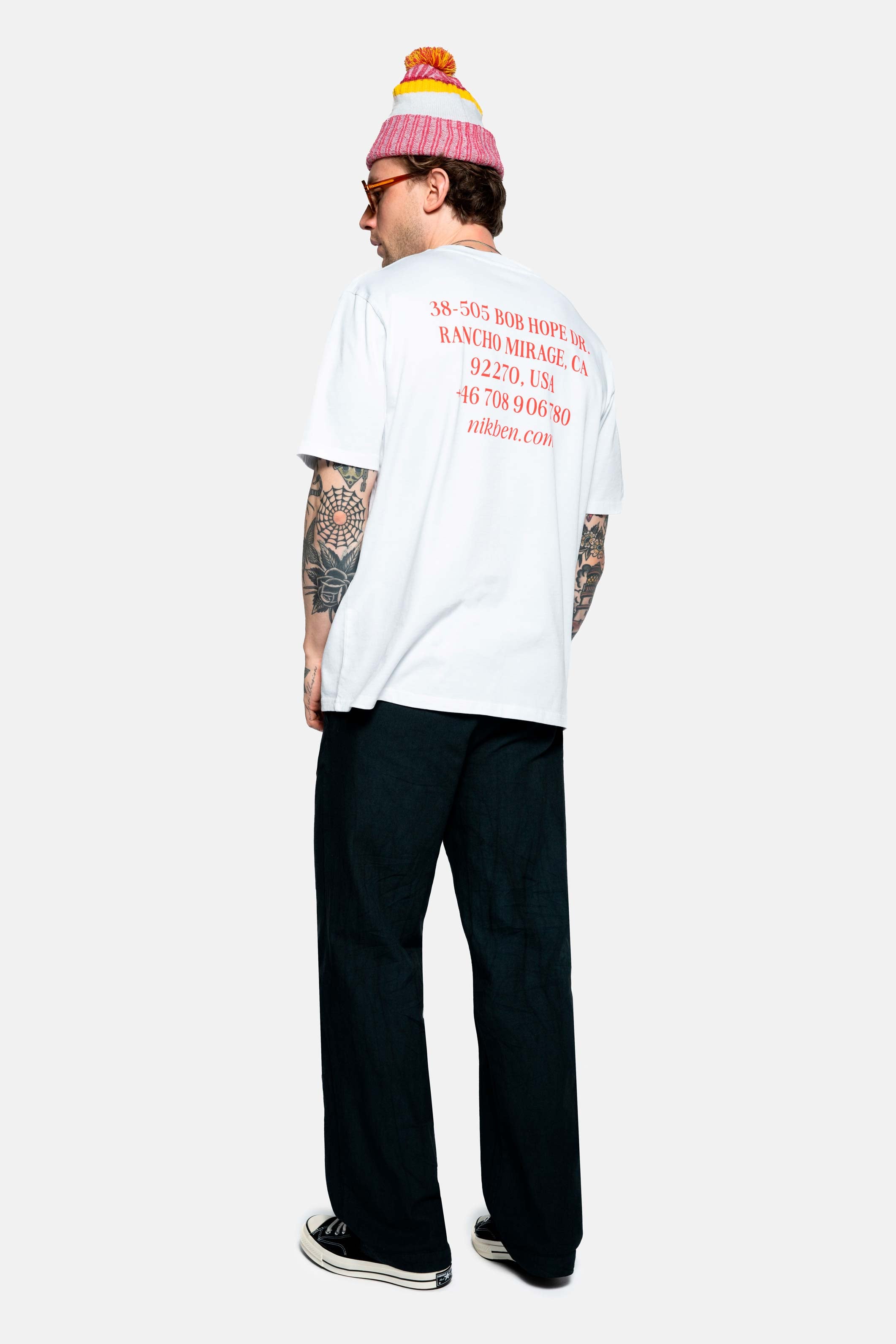 male model wearing a white t-shirt with red back text print