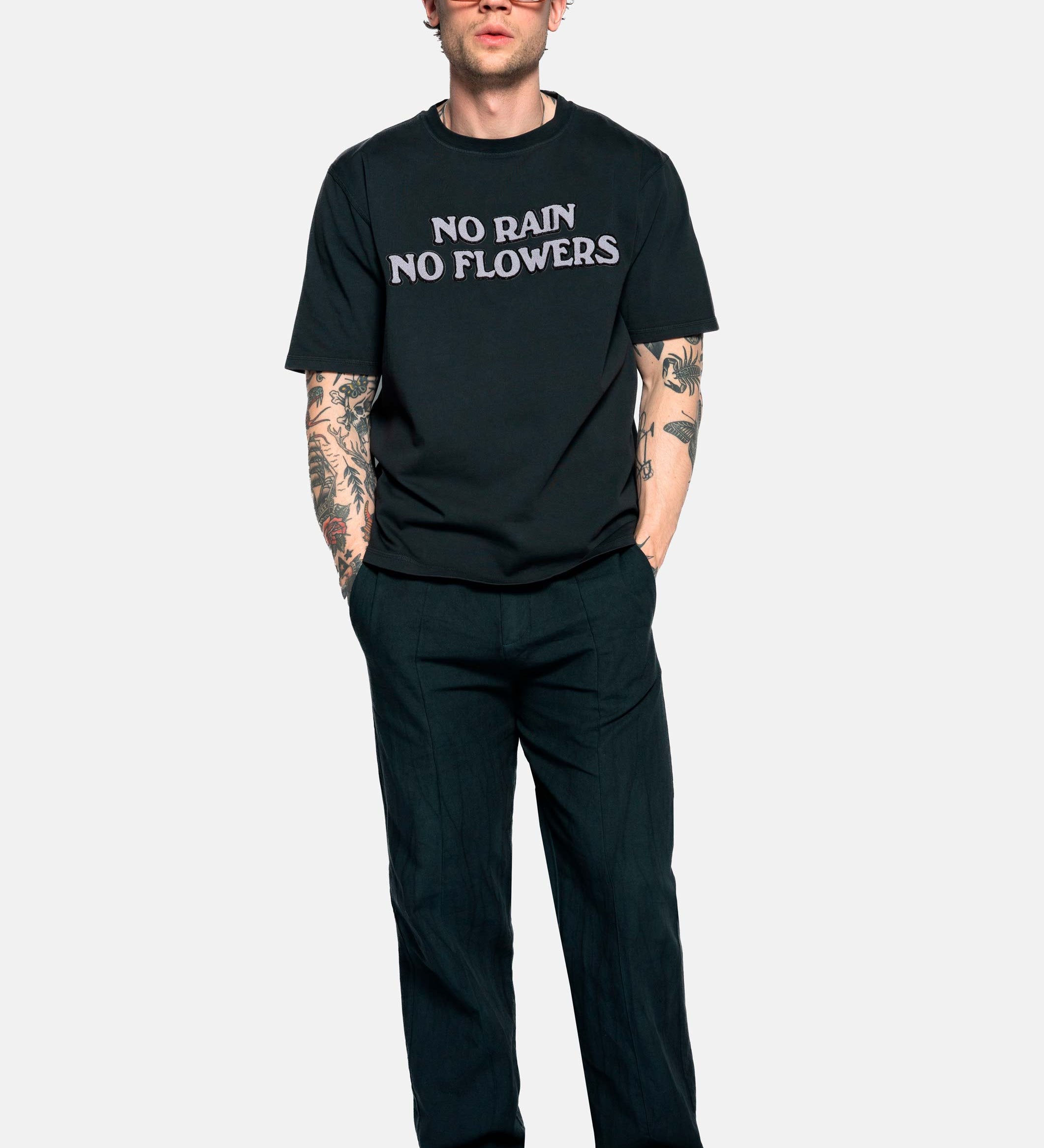 Male model wearing a black t-shirt with "no rain no flowers" felt letters