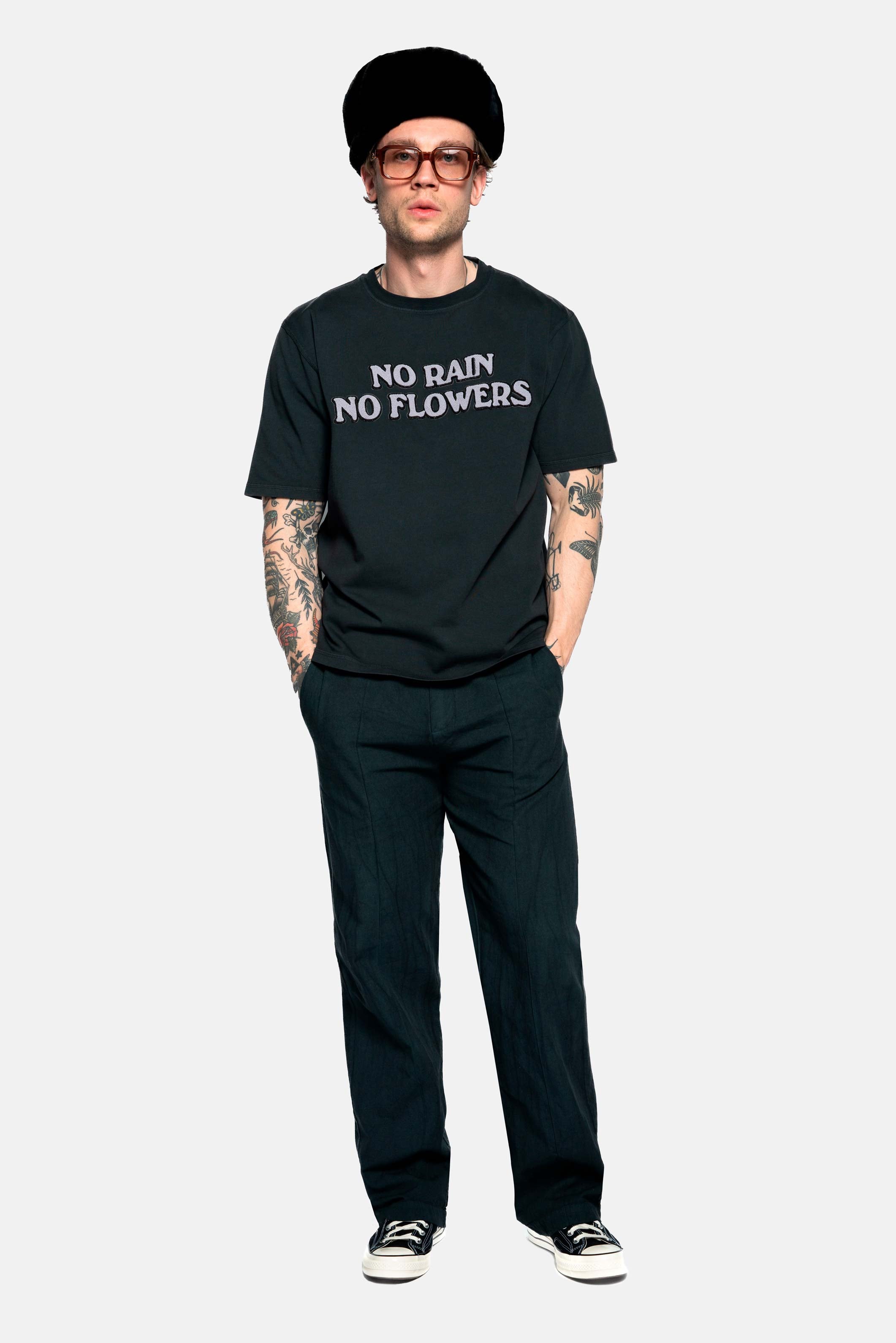 Male model wearing a black t-shirt with "no rain no flowers" felt letters