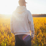 Model wearing beige hoody, with printed logo on the back
