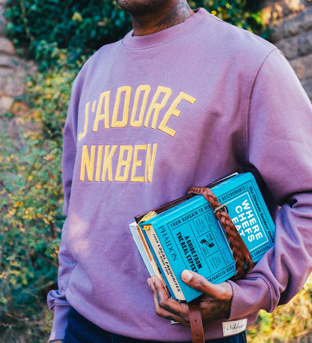 Model wearing purple sweatshirt with yellow front text.