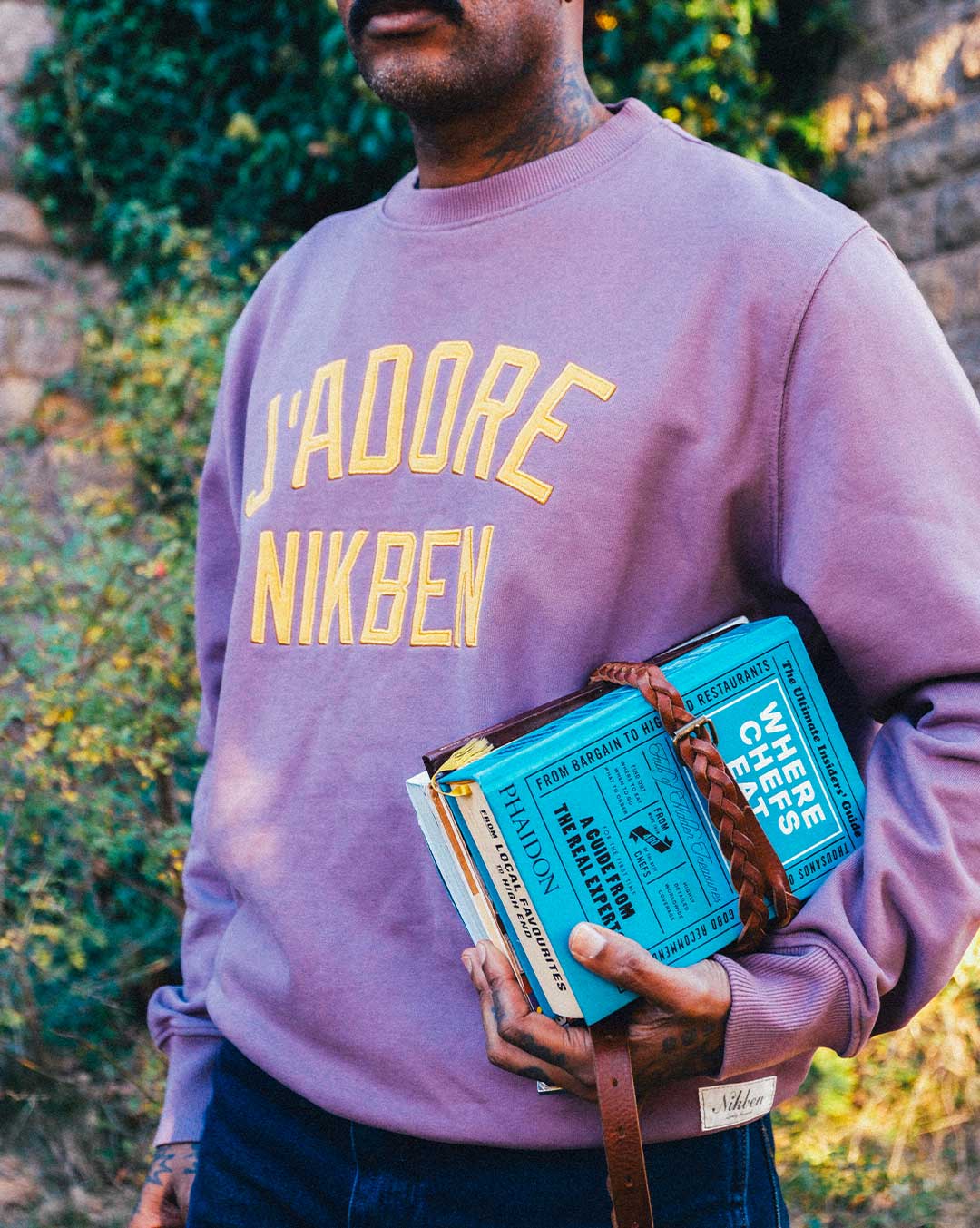Model wearing purple sweatshirt with yellow front text.