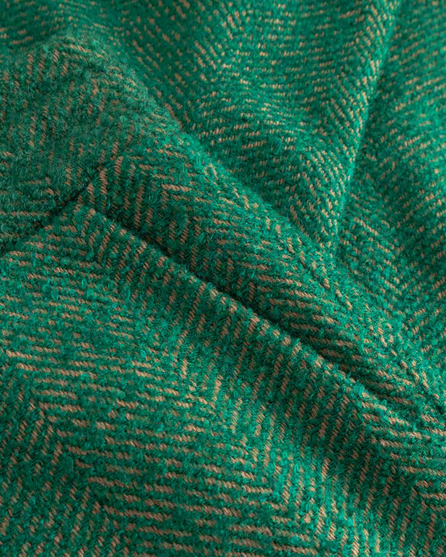 Close-up of green fabric with a herringbone pattern