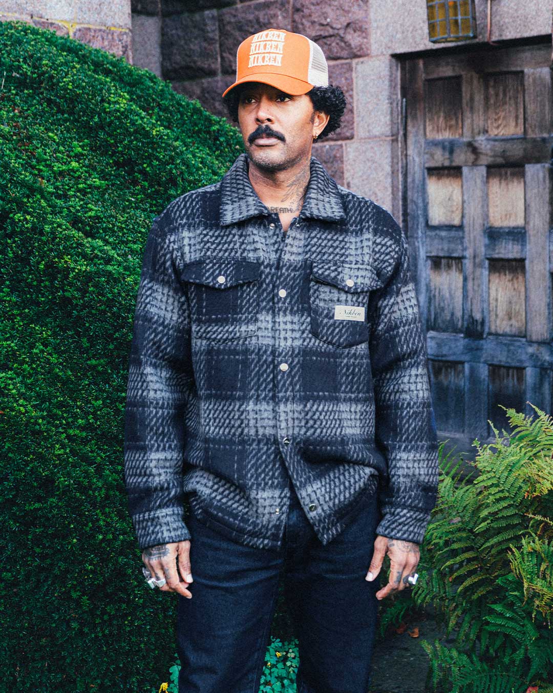 Model wearing navy grey checkered shirt with chest pockets.