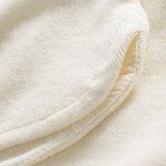 Close up on leg waistband on off white low cut shorts in terry toweling fabric