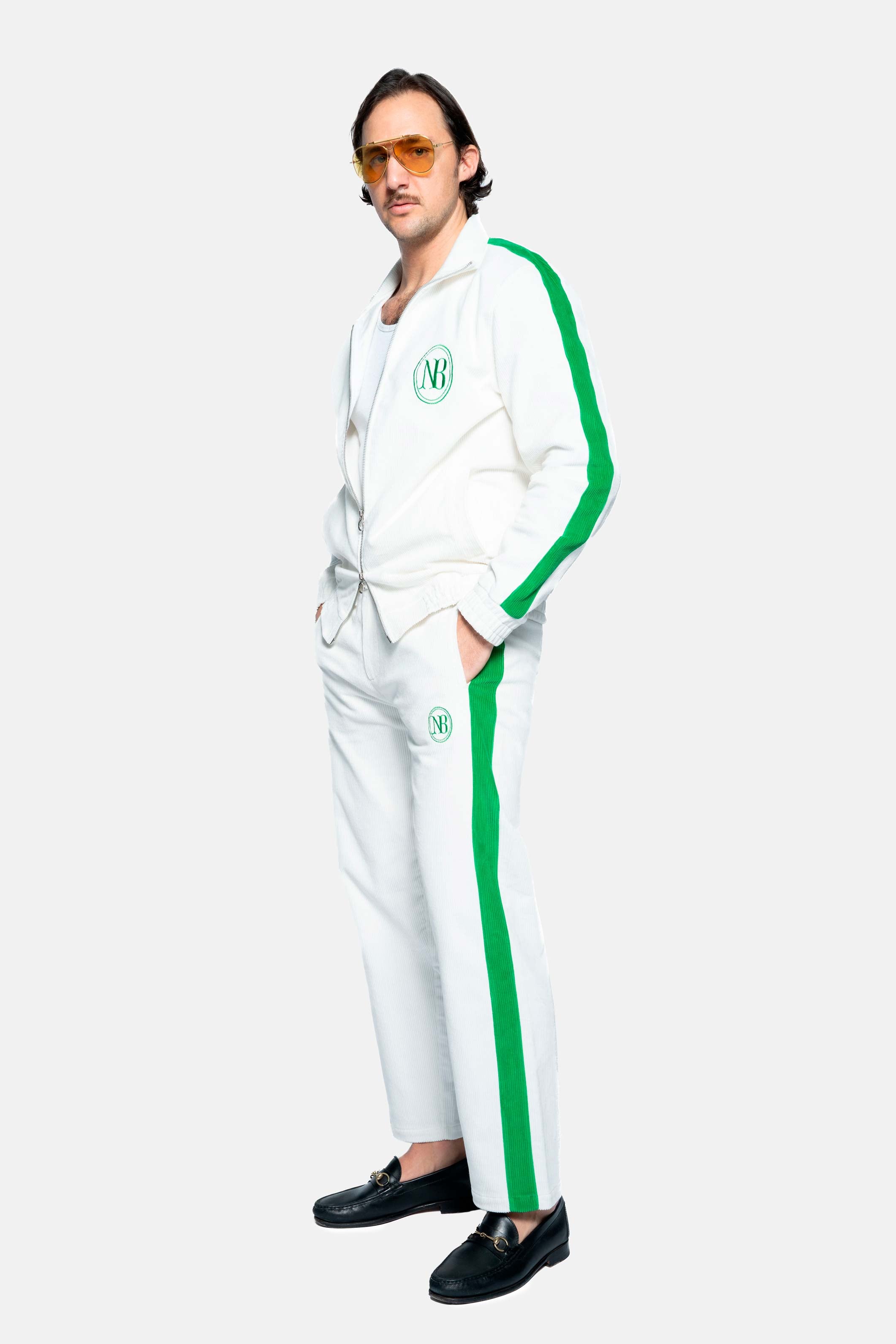 Male model wearing a white and green corduroy track suit jacket with NB embroidery and full zipper