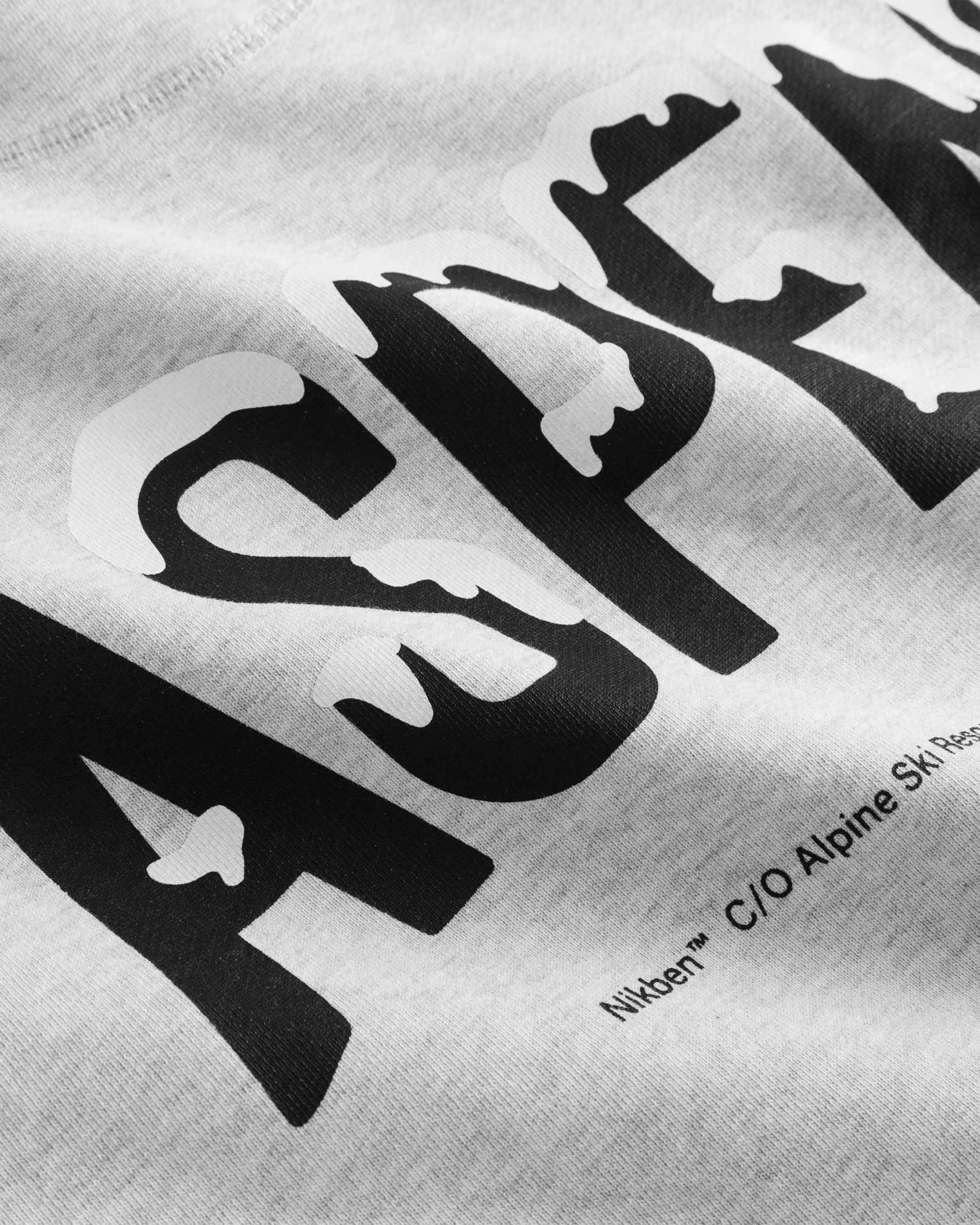 Close-up of black and white text print on a grey hoodie.