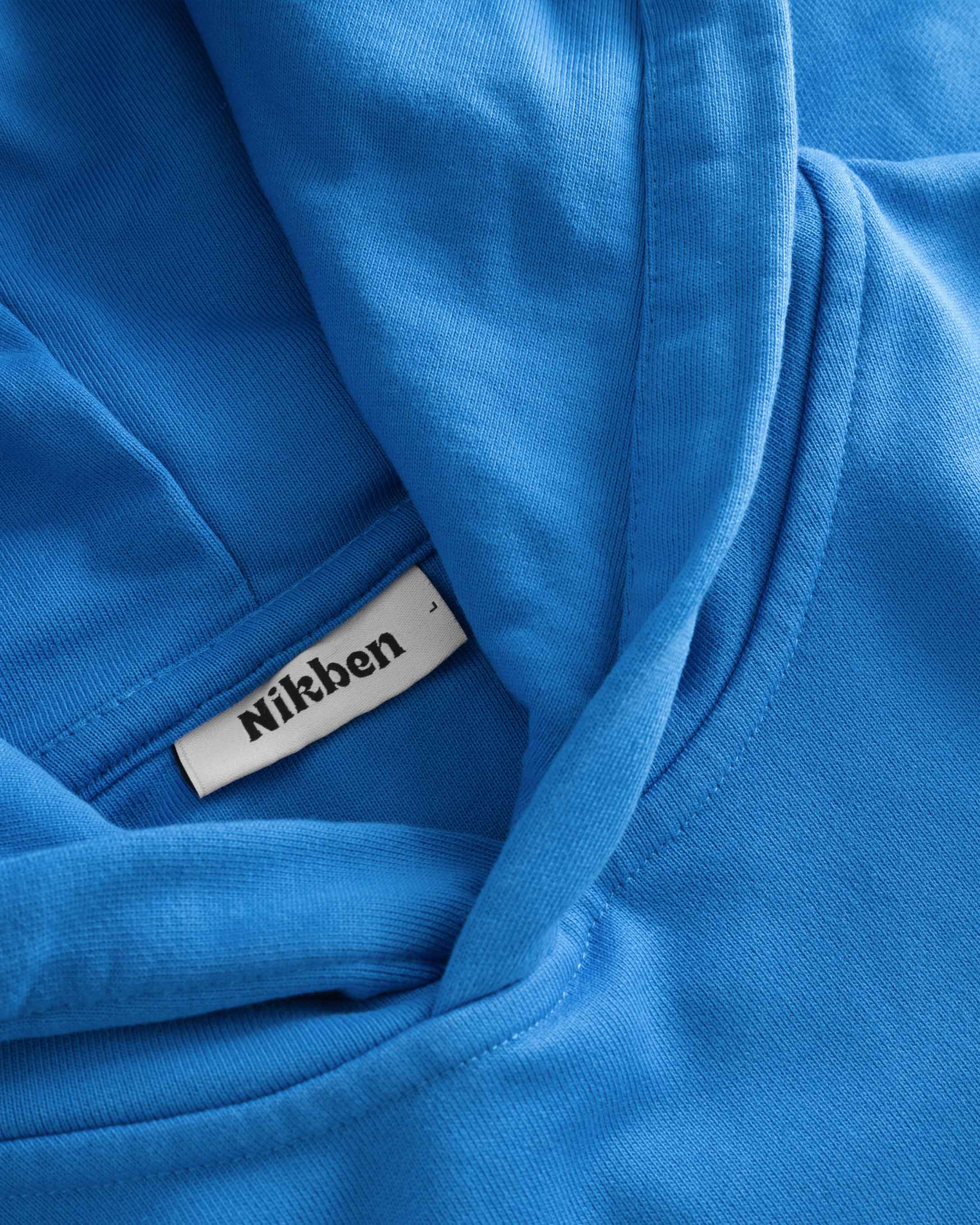 Close-up of stitchings on blue hoodie.
