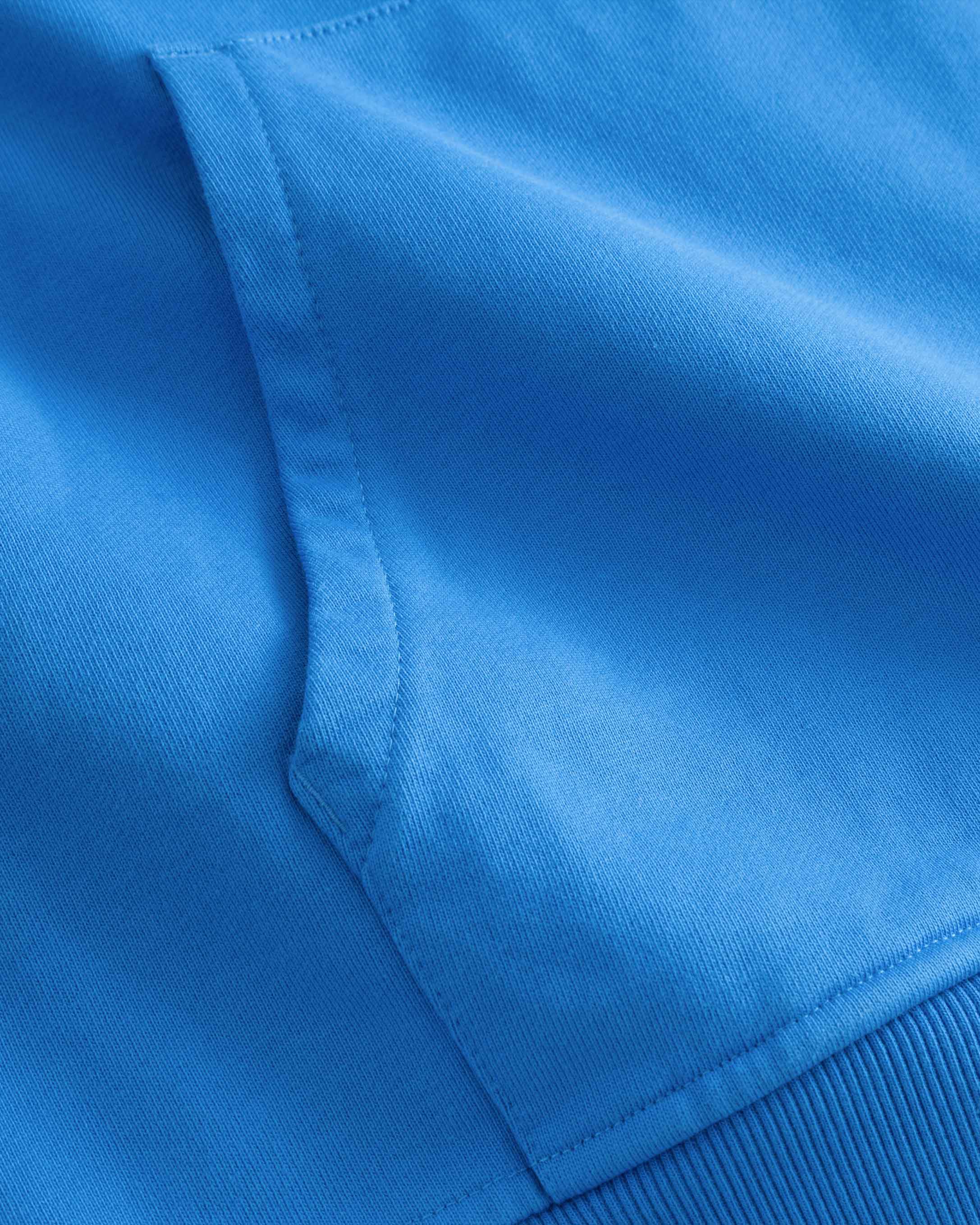 Close-up of single front pocket on a blue hoodie.