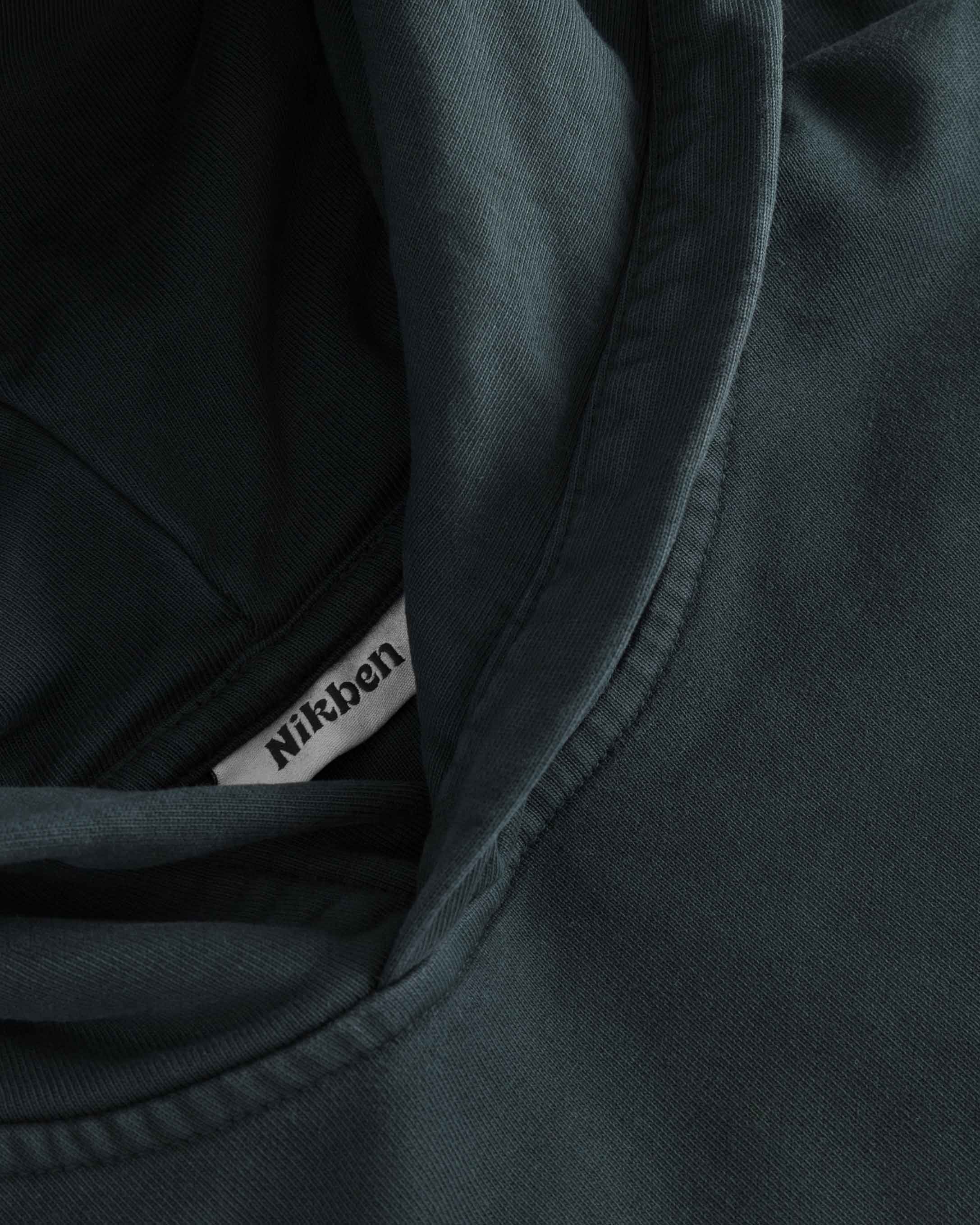 Close-up of stitchings on washed black hoodie.