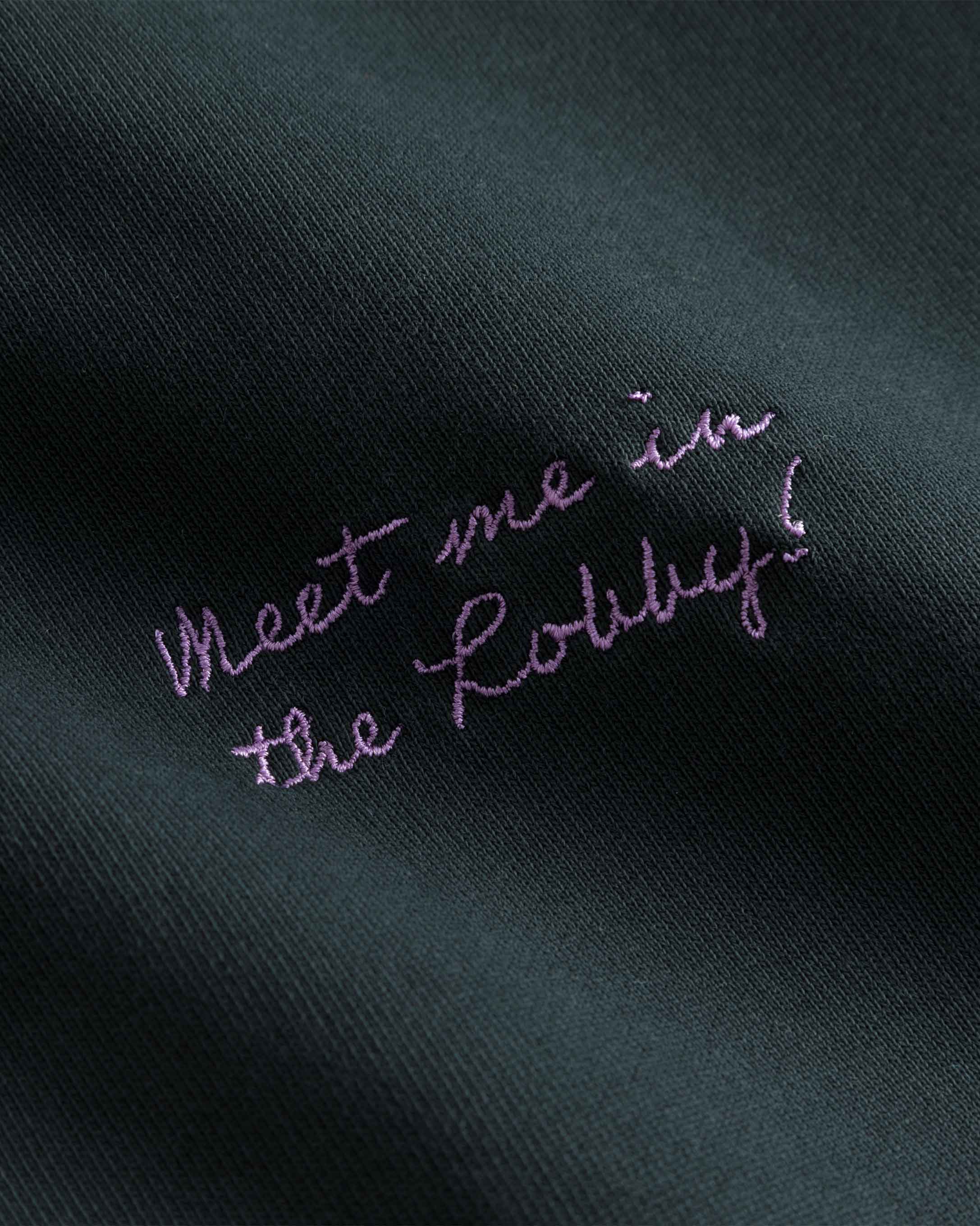 Close up of purple text print on washed black hoodie.