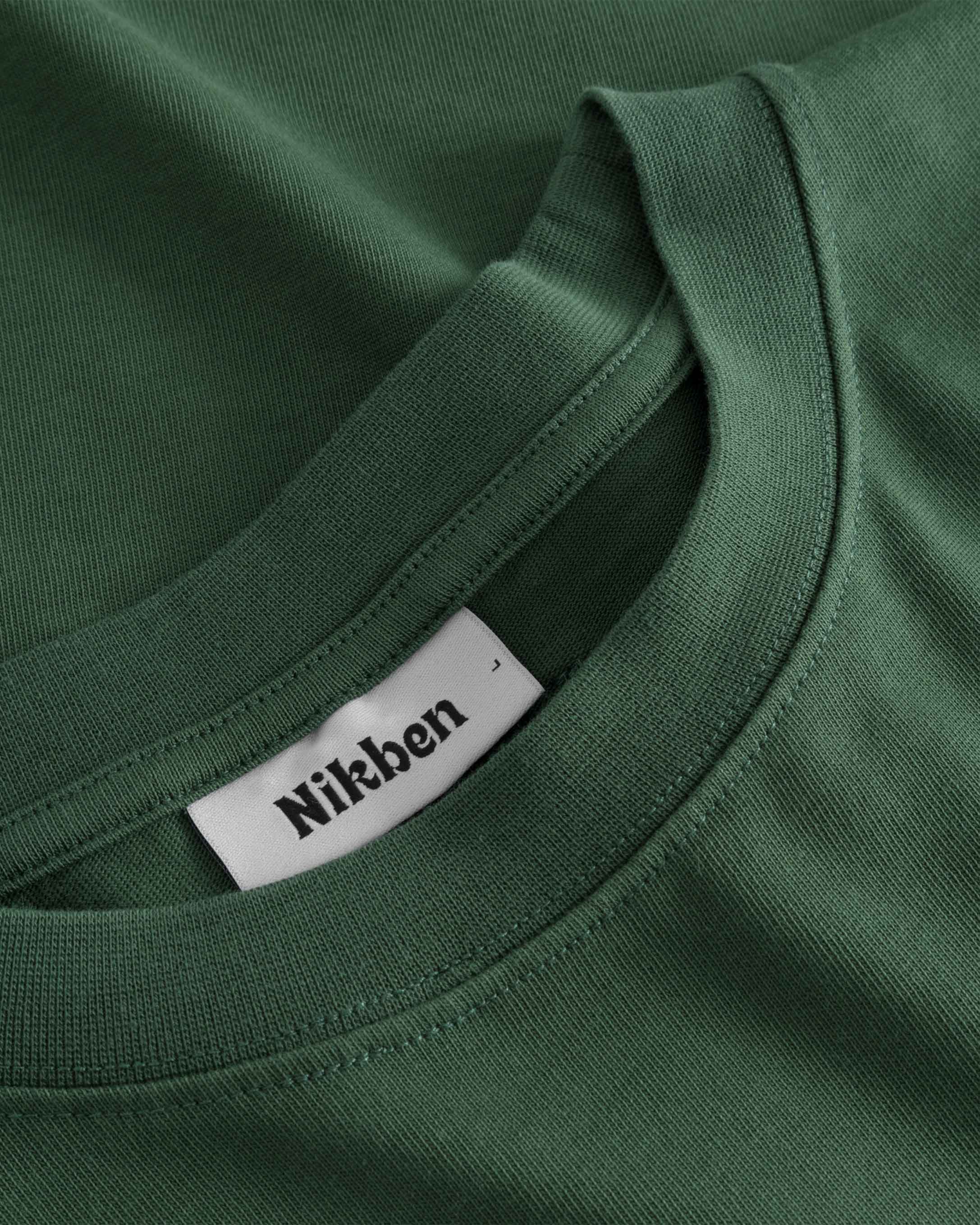 Close-up of round neck and stitching on green T-shirt