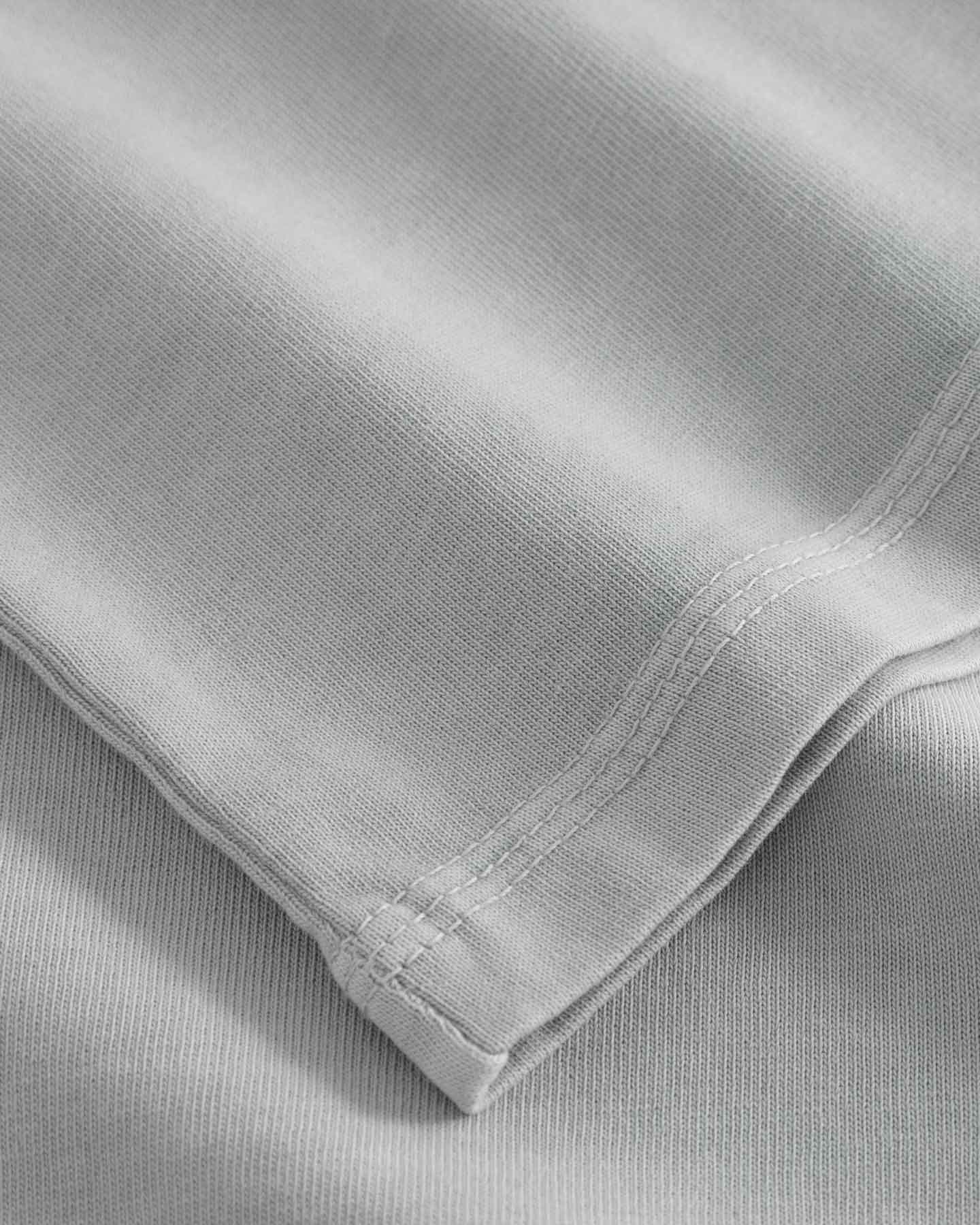 Close-up of sleeve and stitching on washed grey T-shirt