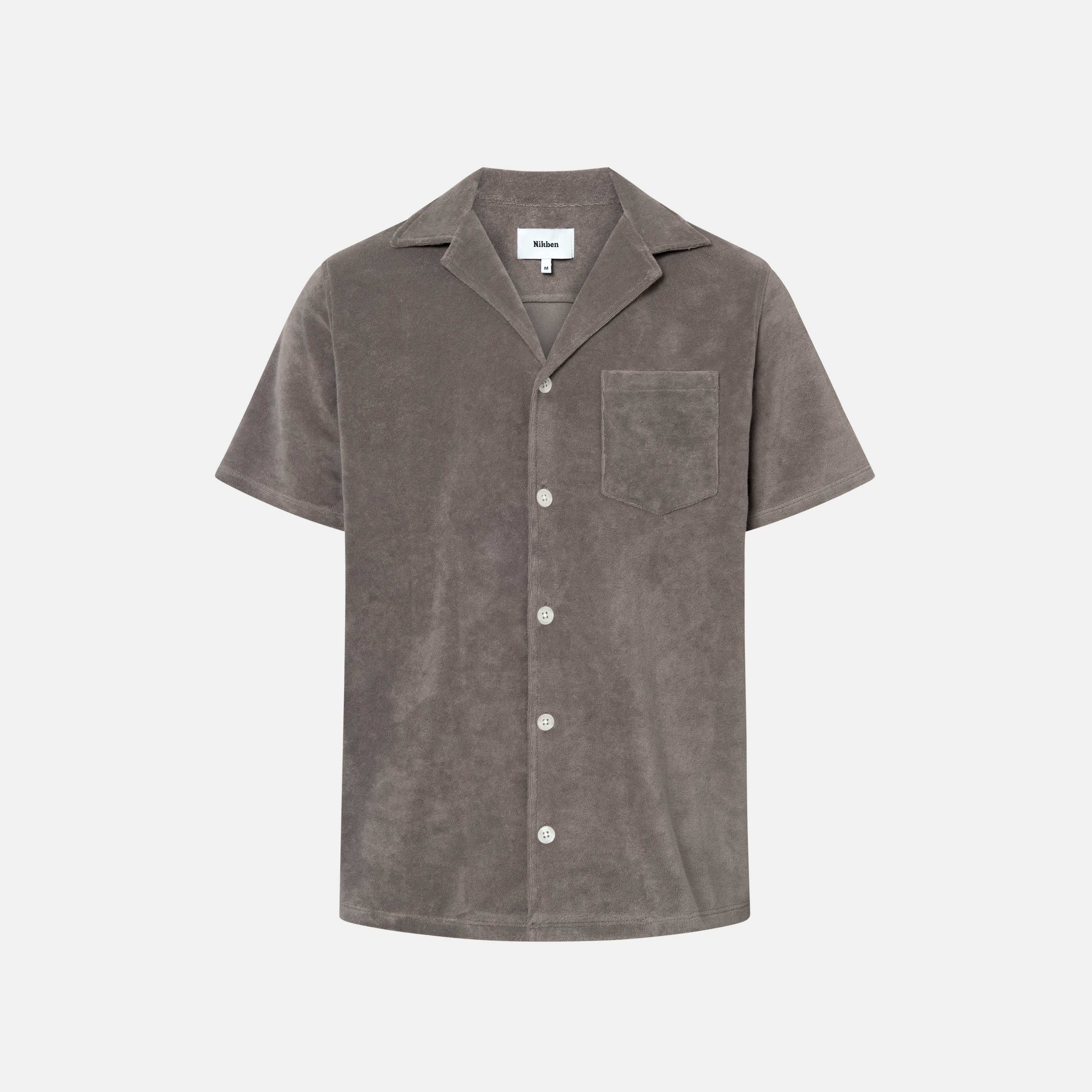 Dark grey short sleeve shirt with white button closure and one chest pocket
