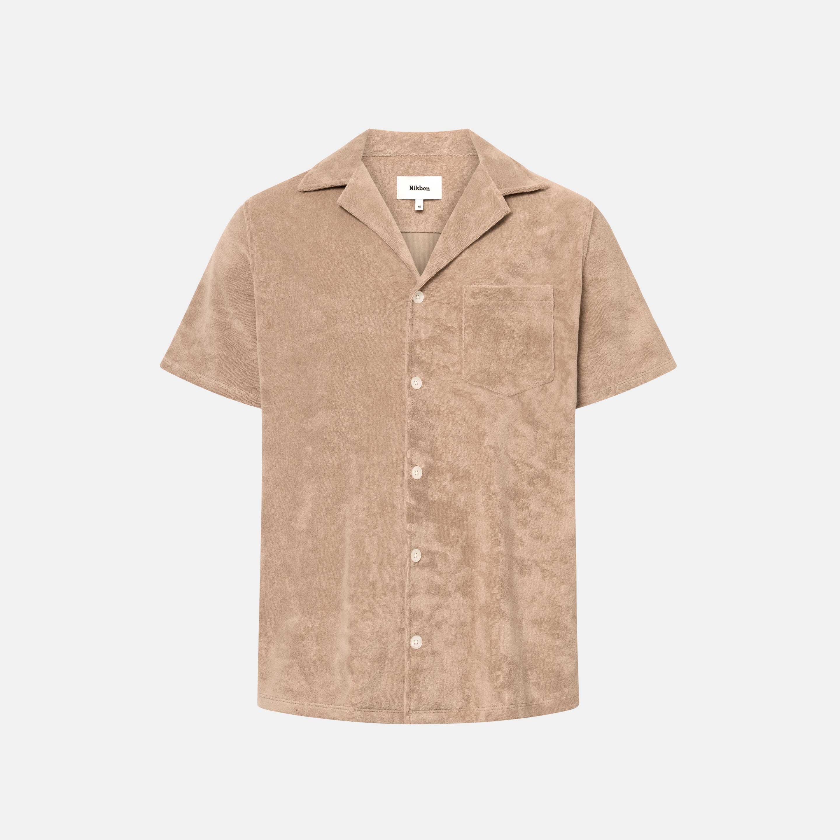 Light brown short sleeve shirt with white button closure and one chest pocket