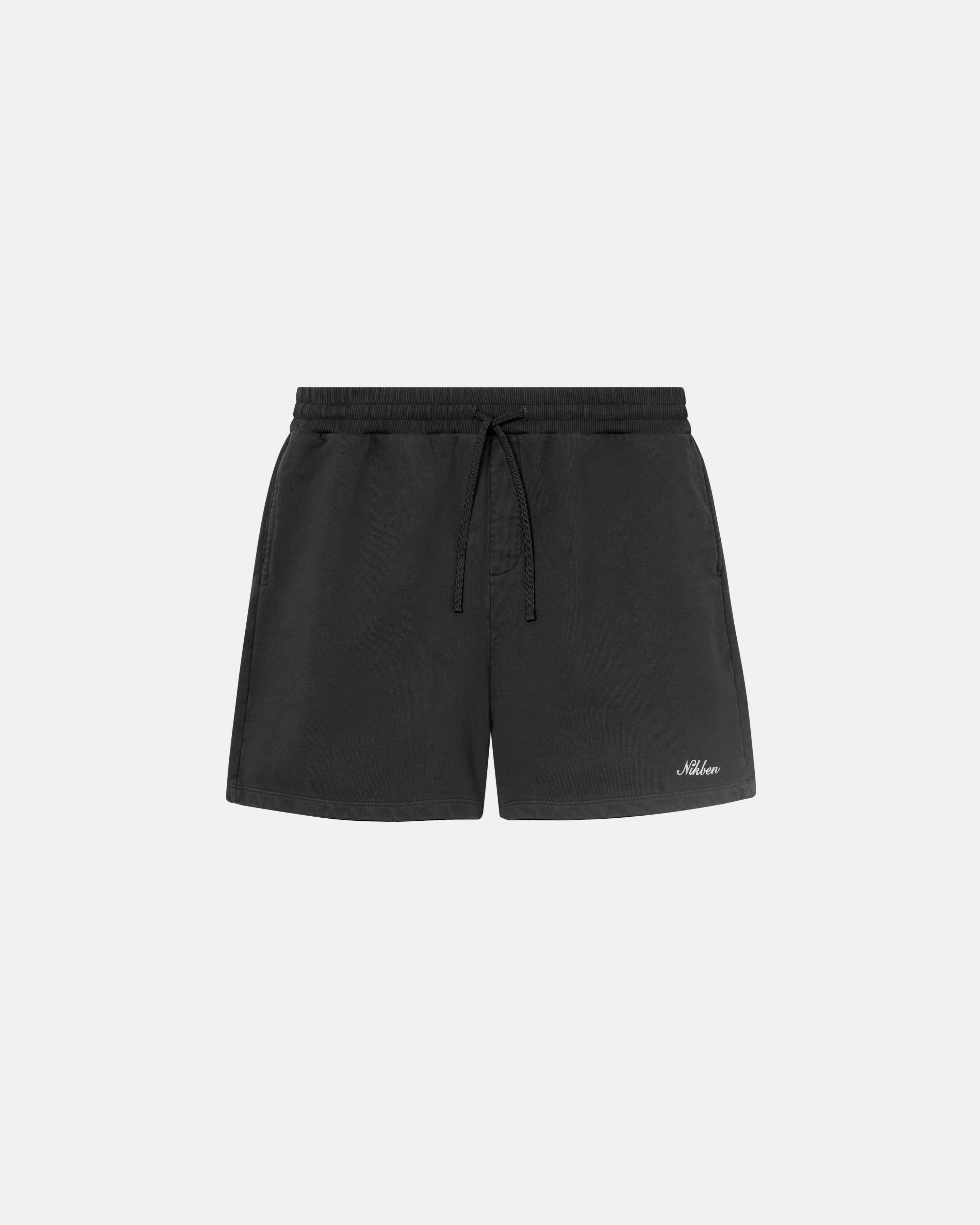 Black washed sweatshorts with elastic drawstrings and an embroidered script logo on the front leg
