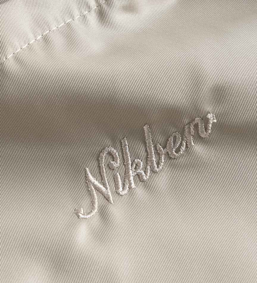 Close up on embroidered logo on a pair of beige polyester shorts