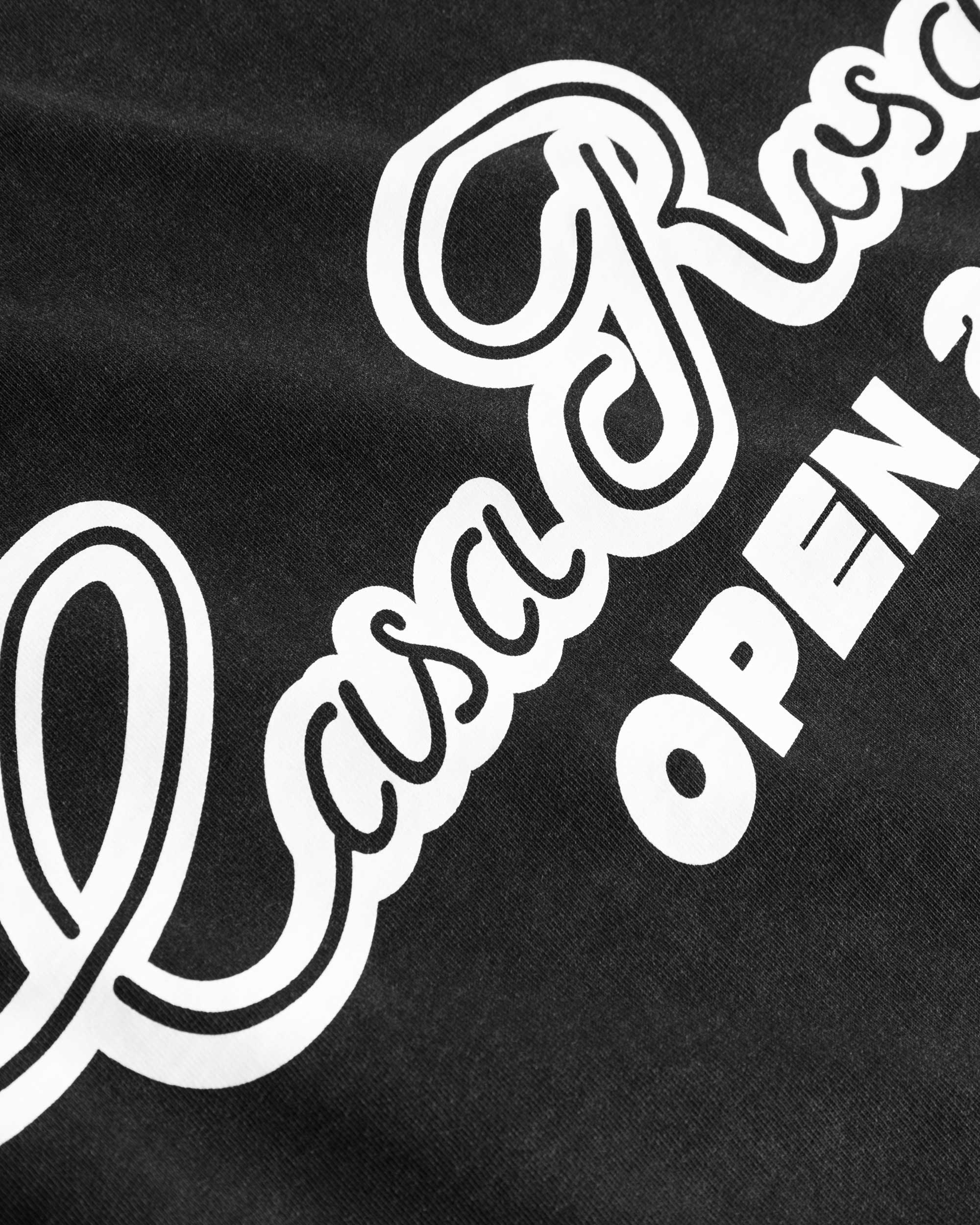 Close up view of white text print on black t-shirt.