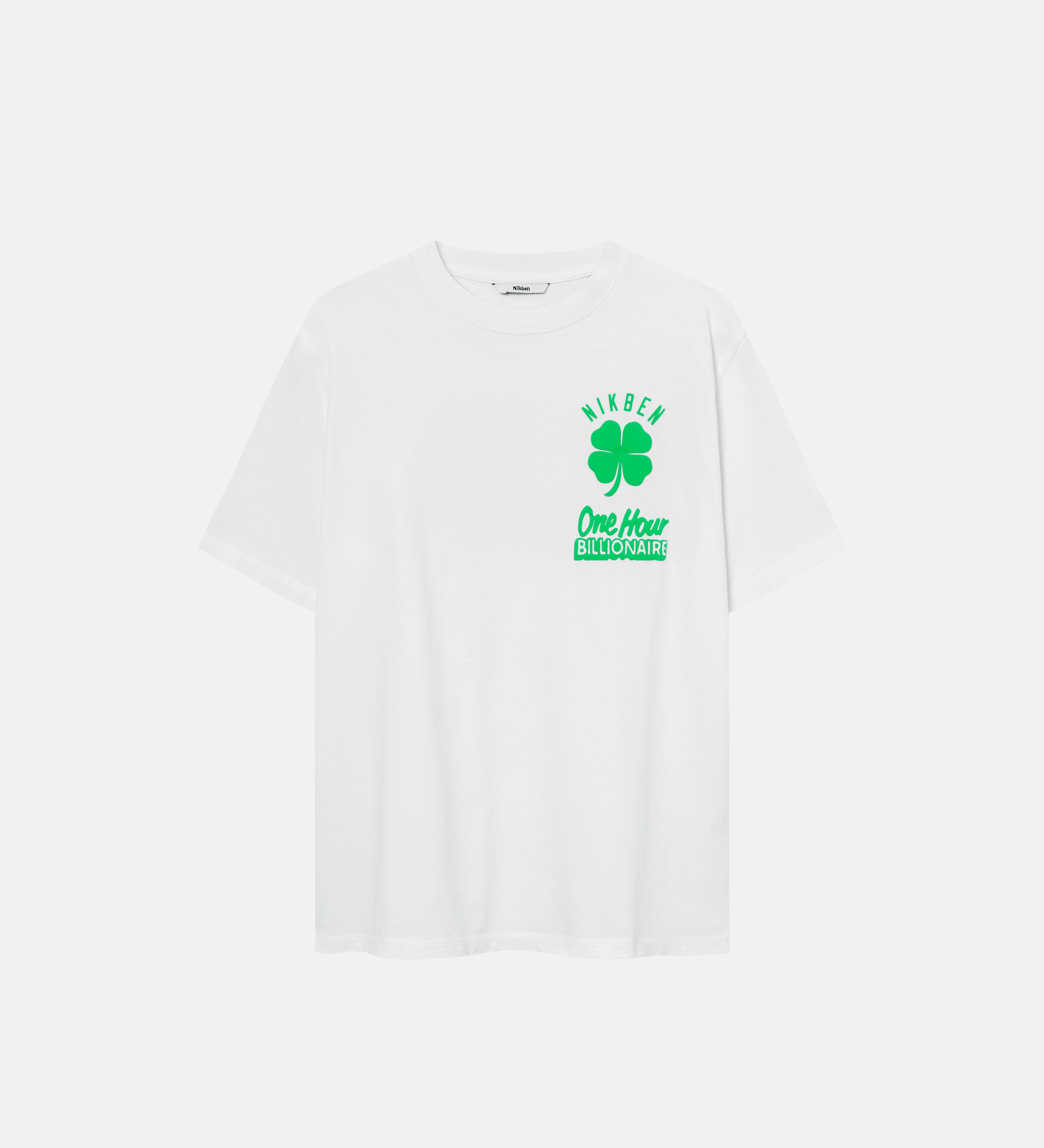 White t-shirt with a green clover print and the text "One Hour Billionaire"