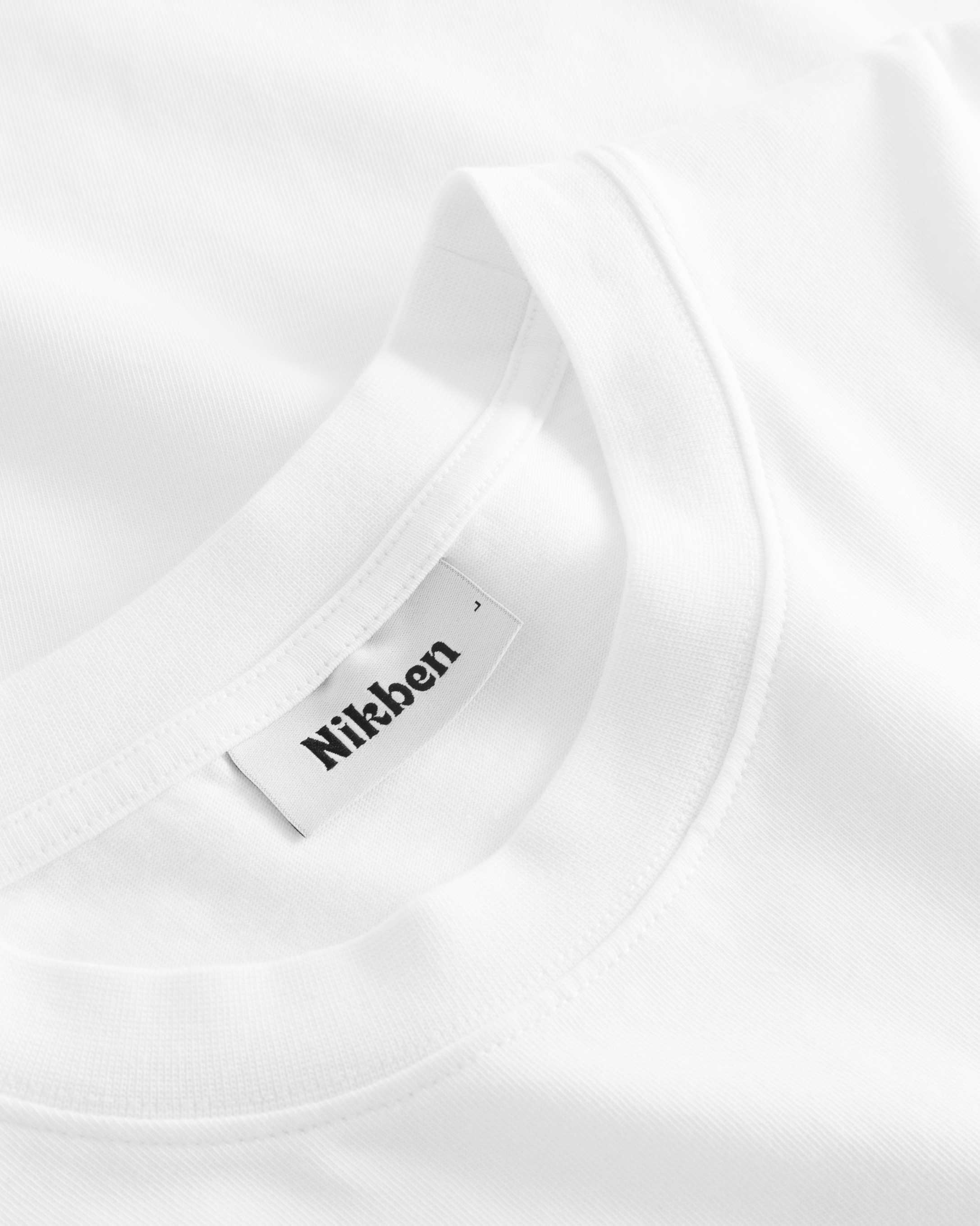 Close-up view of the round neck and stitchings on white t-shirt.
