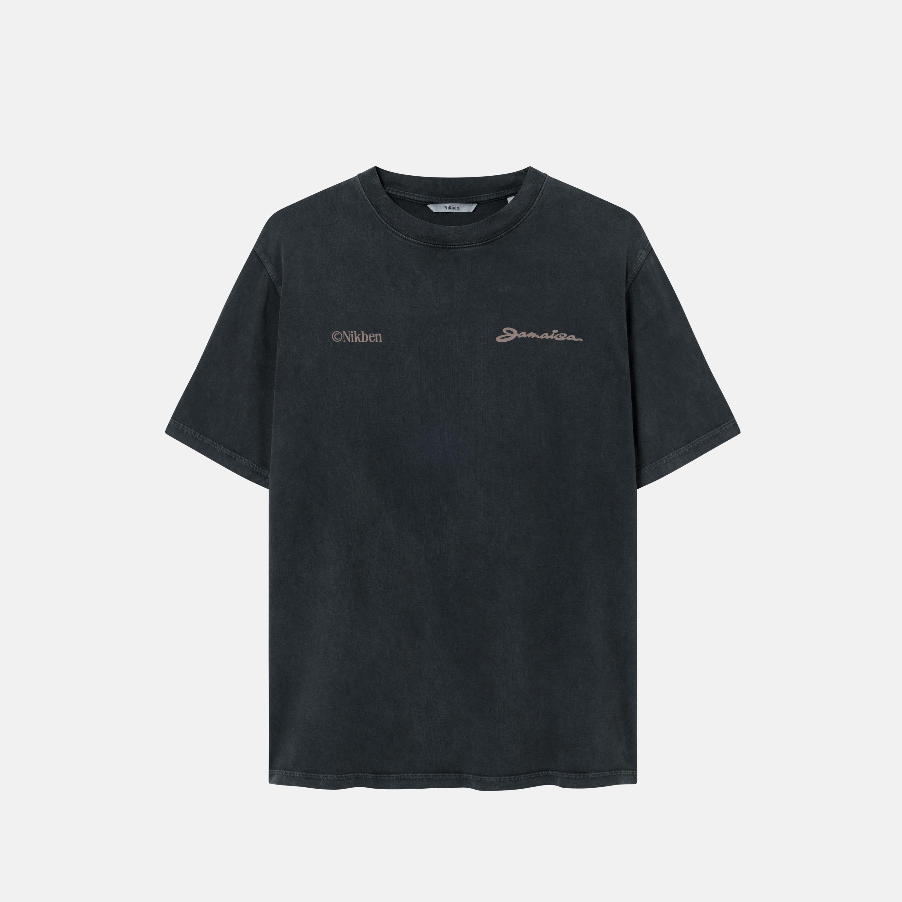 A sand colored t-shirt with "jamaica" text print on a black garment dyed t-shirt 