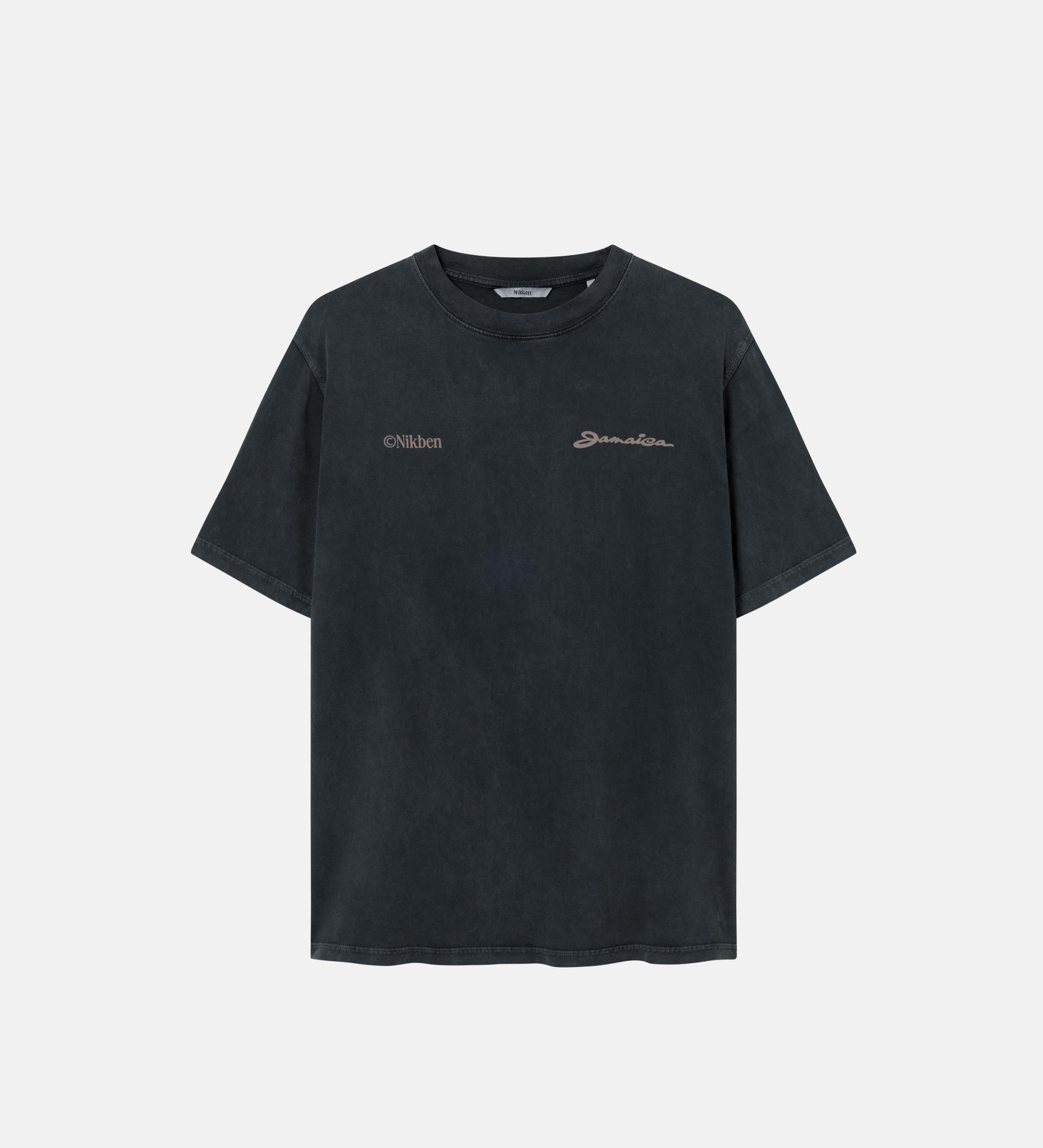 A sand colored t-shirt with "jamaica" text print on a black garment dyed t-shirt 
