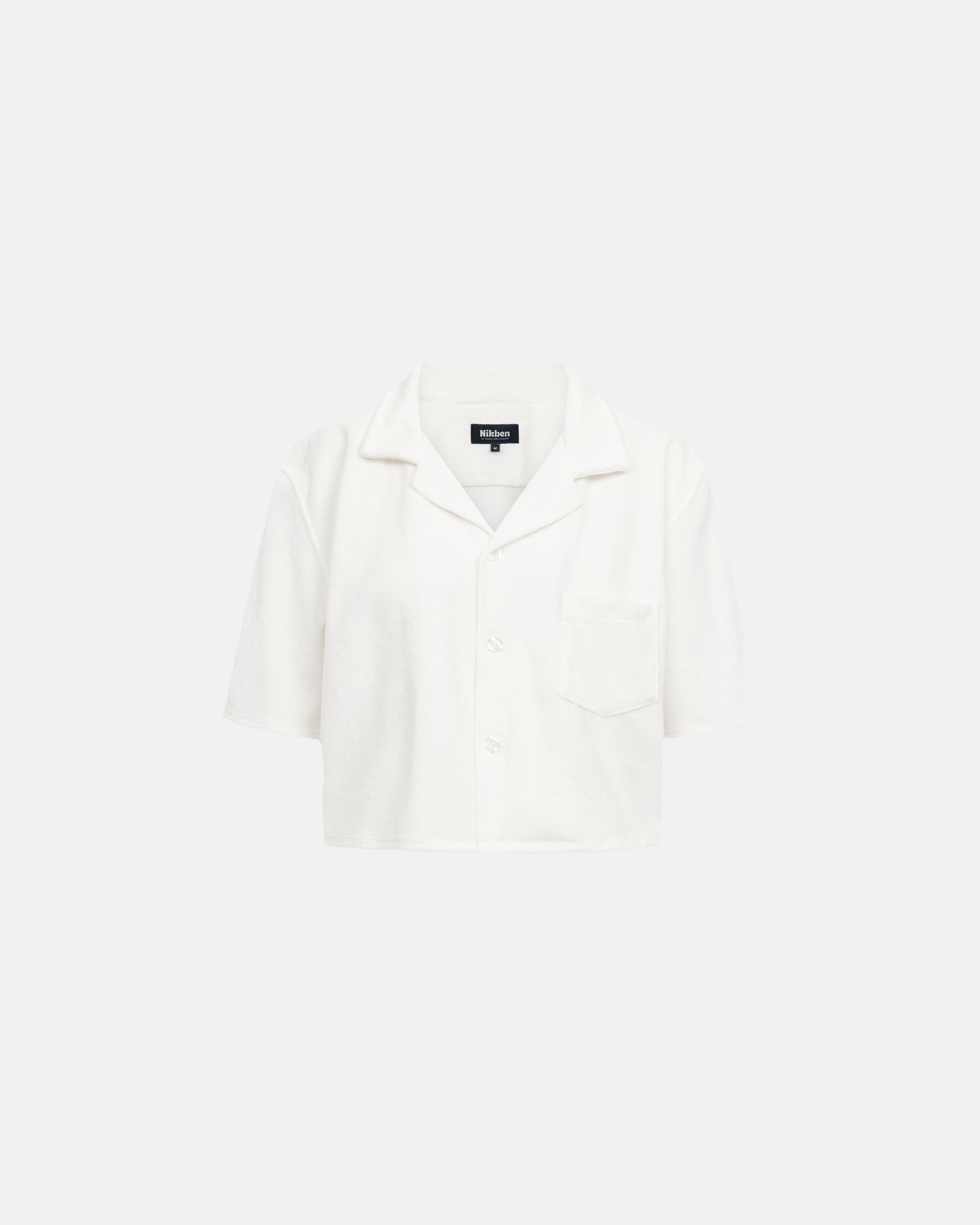 White, short sleeve, cropped shirt with white button closure and one chest pocket