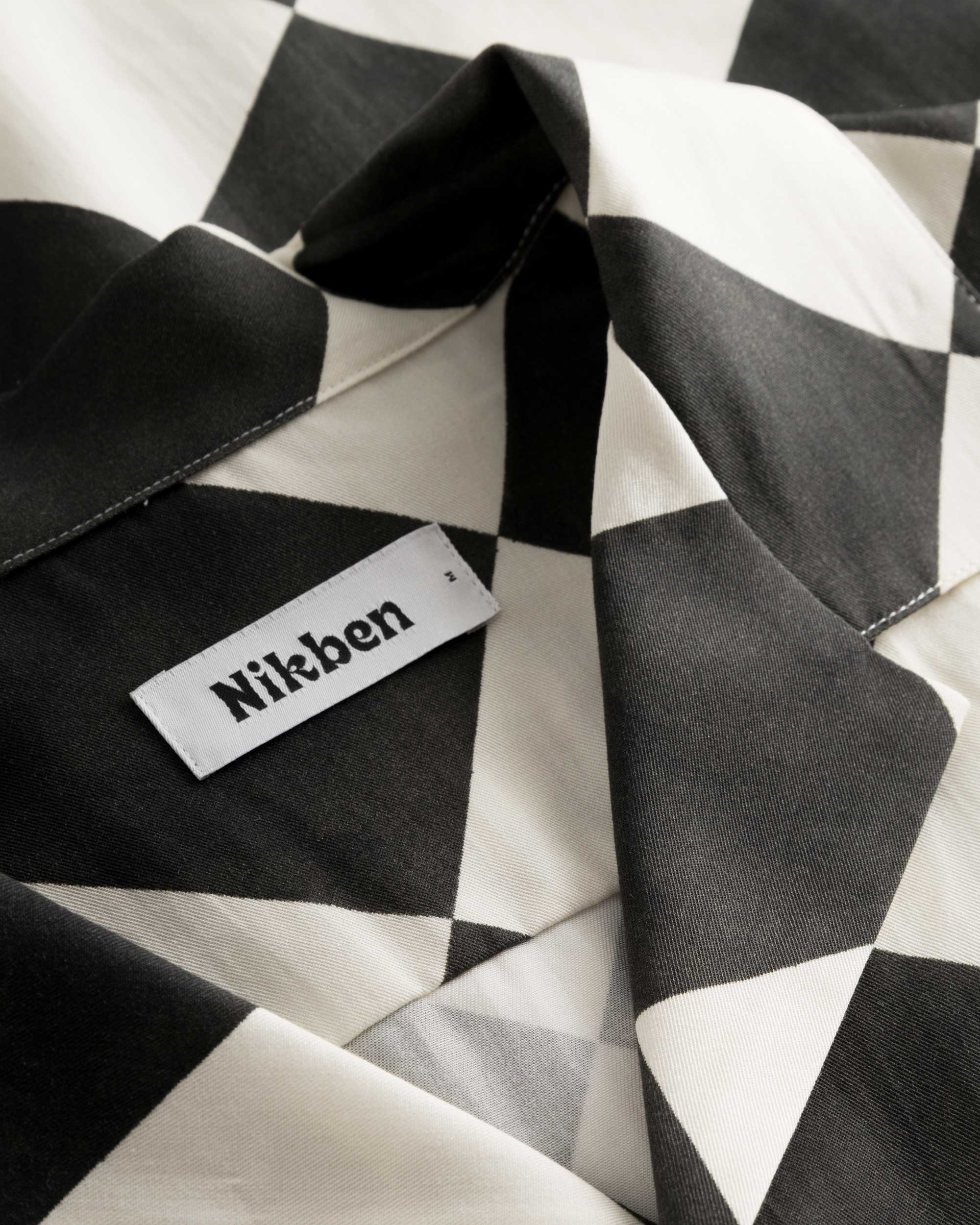 Close-up of the open collar on a black and white vacation shirt.