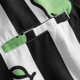 Close-up on breast pocket on a black and white short-sleeved vacation shirt with green pear illustrations.