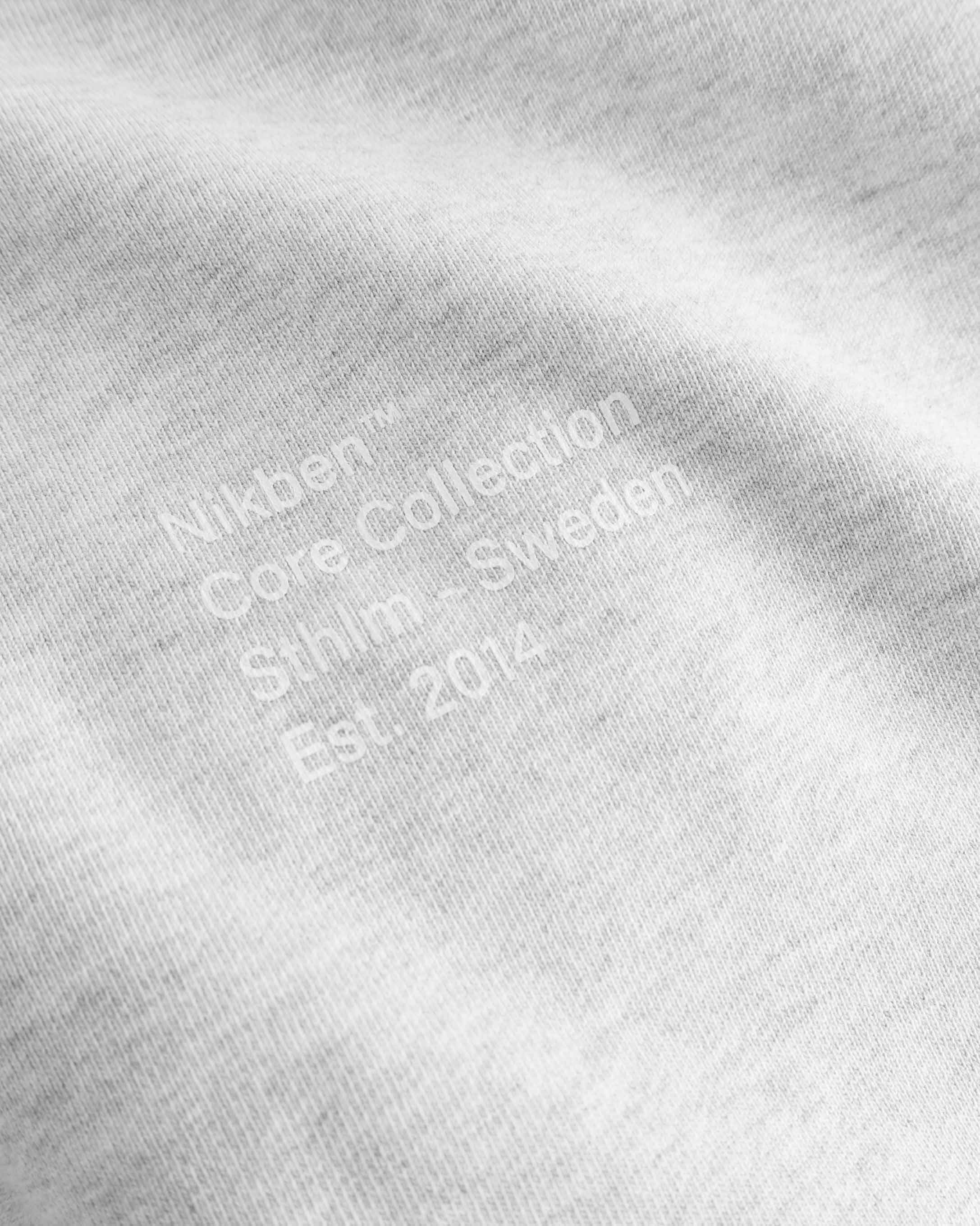 Close up view of white text print on grey hoodie.