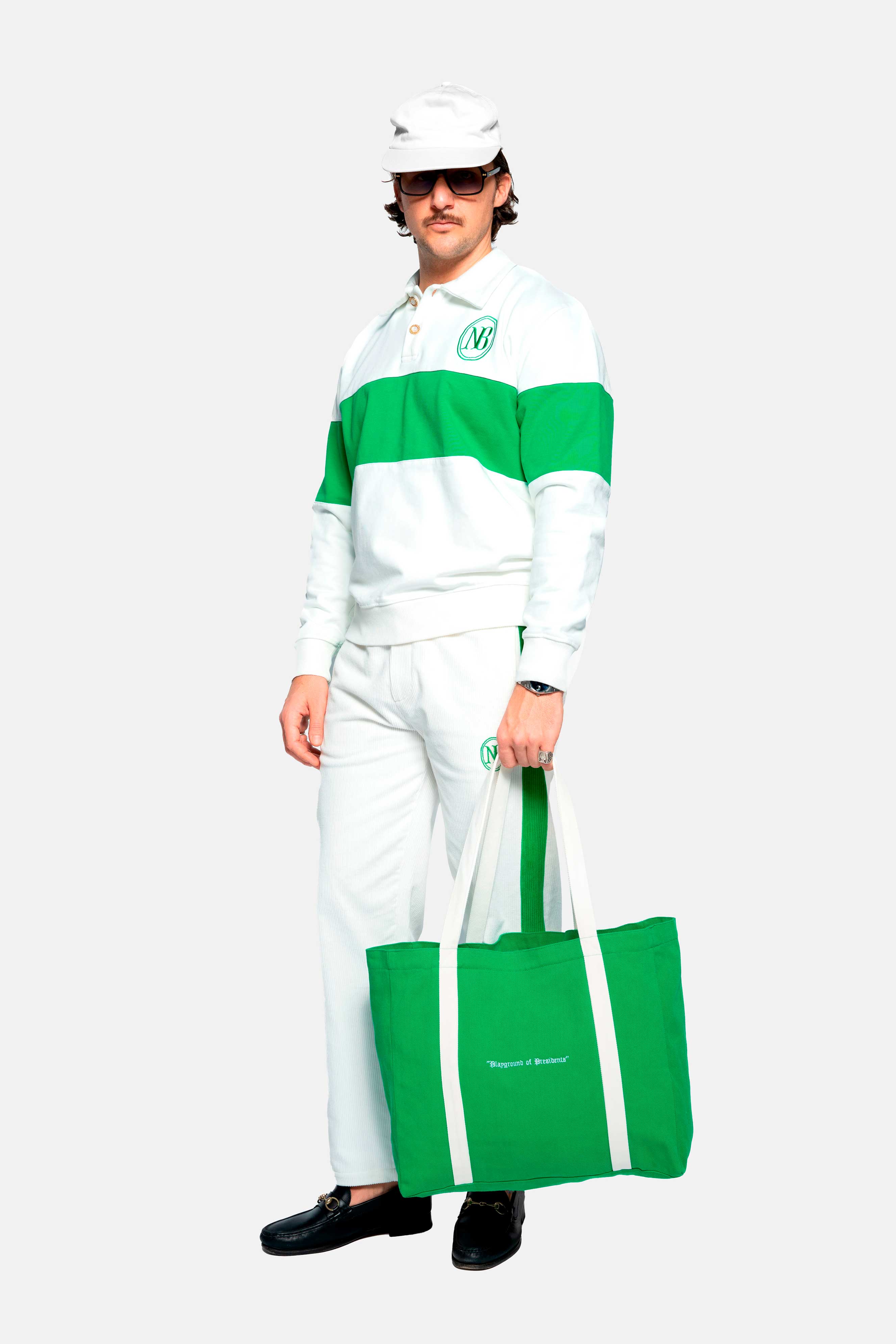 Male model wearing a white and green long sleeved polo shirt whit embroidered NB logo and ribbed cuffs