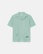 Mint green waffle-patterned short-sleeved shirt with two front pockets, featuring a stitched black Nikben logo on the left pocket and button closure.