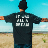 model wearing a black t-shirt with 'IT WAS ALL A DREAM' on the back.