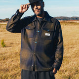 model wearing dark blue and green flannel overshirt with front pockets