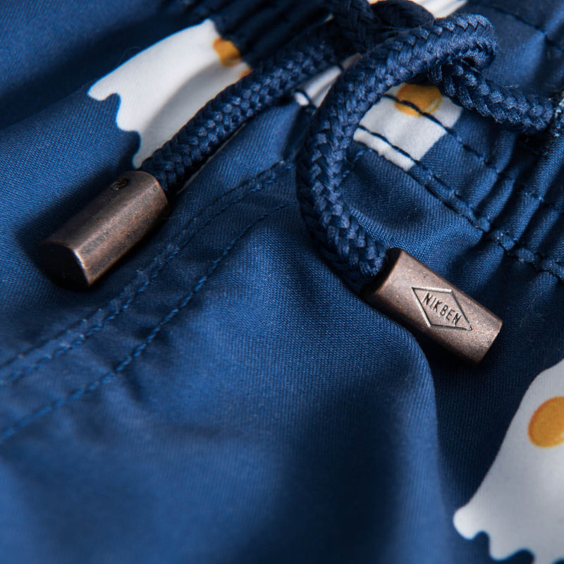 Drawstring waistband on blue kids swim trunks with print