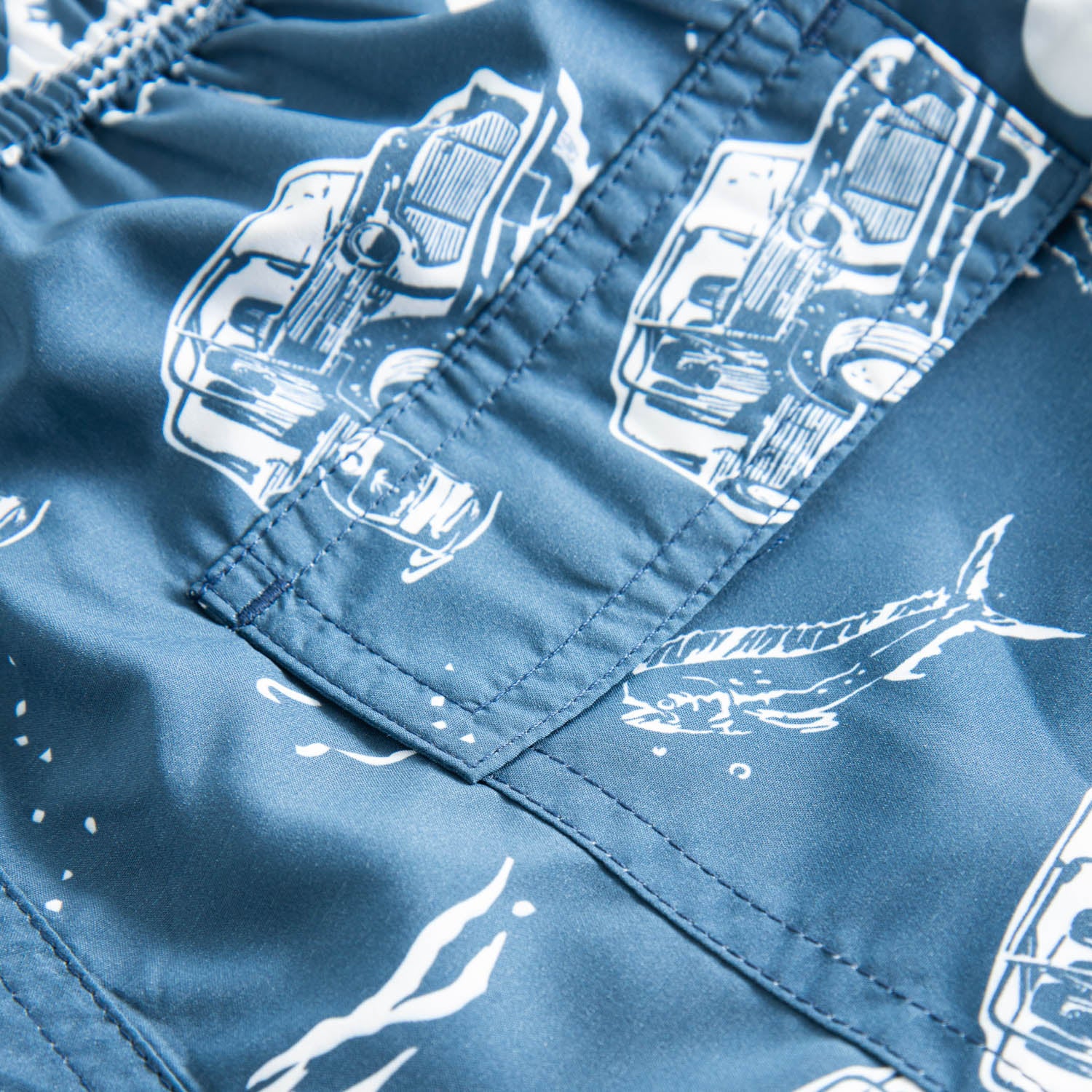 Back pocket on blue kids swim trunks with white print