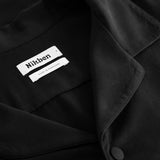 Collar, button and neck label on black shirt