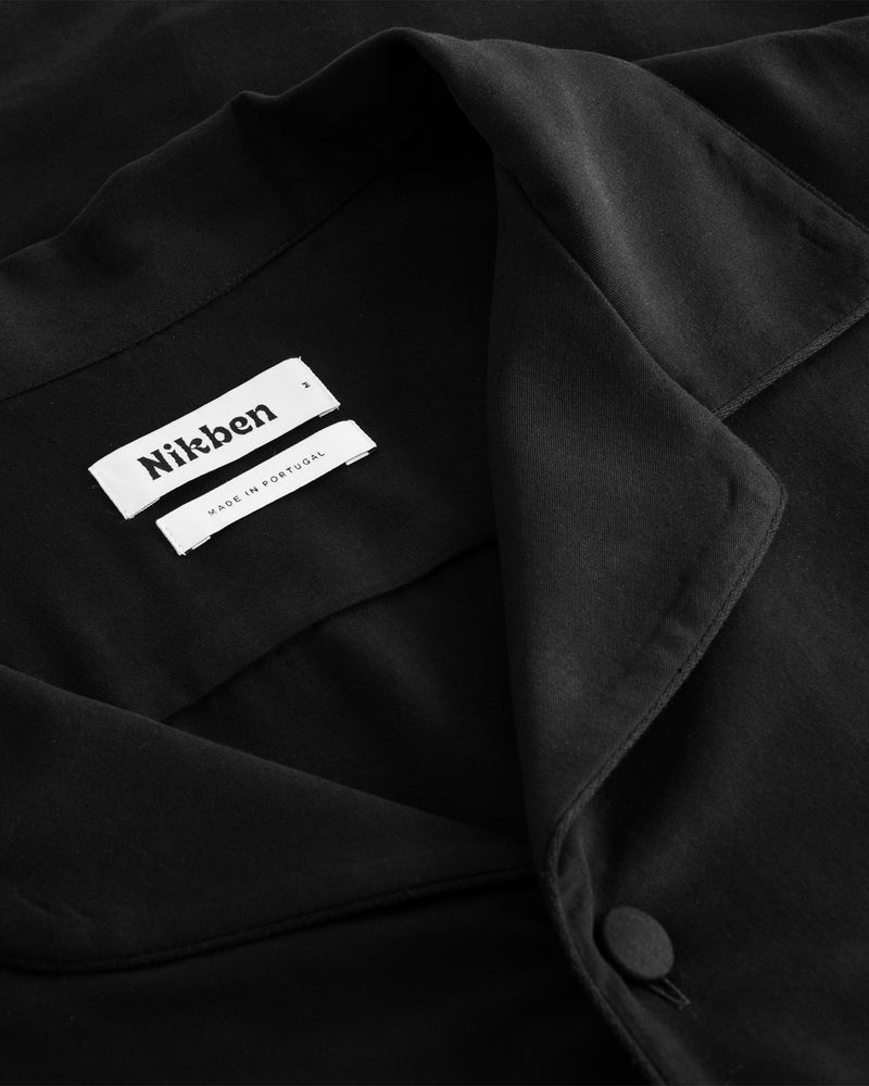 Collar, button and neck label on black shirt
