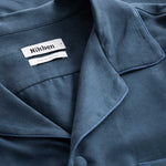 Collar, button and neck label on blue shirt