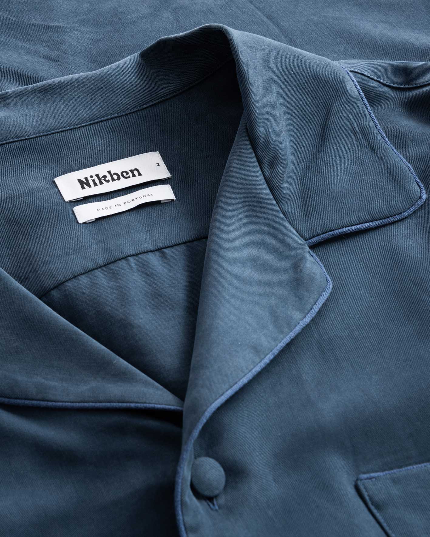 Collar, button and neck label on blue shirt