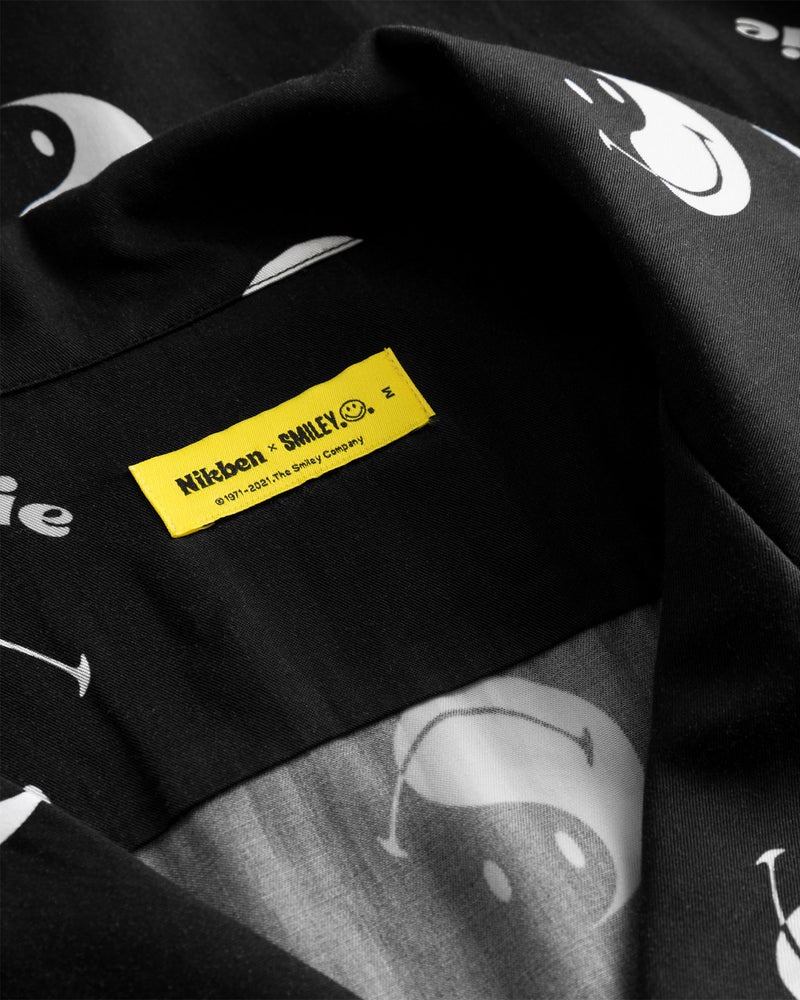 Yellow neck label on black shirt with white smiley print