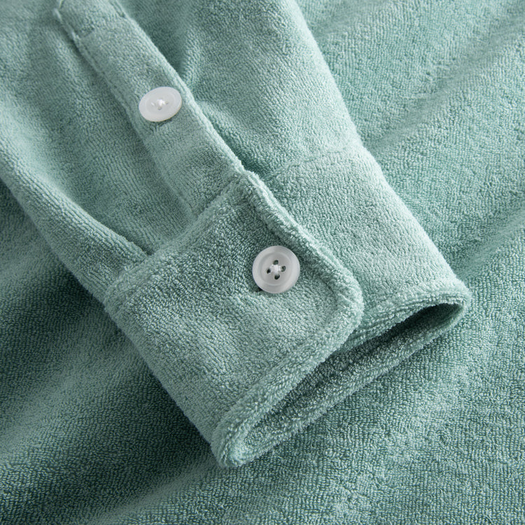 Sleeve with white buttons on green Terry toweling shirt